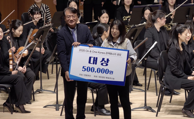 ‘통일, 화합’ 주제 관객 메시지 공모 대상은 ‘우리의 소원은 통일’이 선정됐다. 왼쪽부터 이종원 재단법인 통일과나눔 상임이사, 신지호 수상자