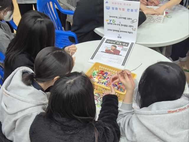 다양한 체험부스 중 청소년들이 평화 부스에서 키링을 만들고 있는 모습