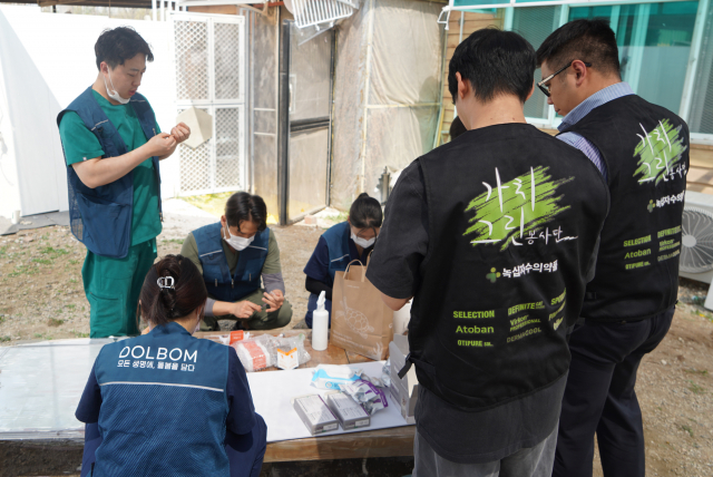 돌봄동물병원 소속 수의사와 직원, 녹십자수의약품 가치그린봉사단원이 동물의료봉사를 위해 약품을 정리하고 있다